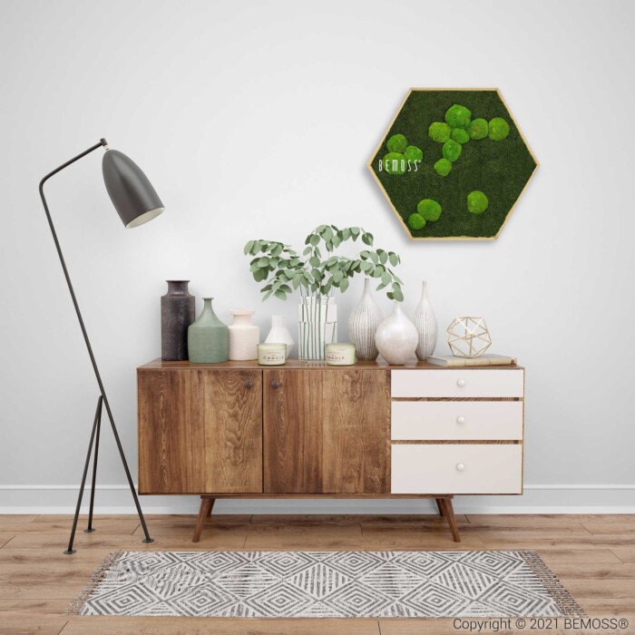 ein Zimmer mit einer Kommode und einer darüber hängenden grünen Wand und einer Lampe auf dem Sideboard mit einer Pflanze, moosbild, mooswand, moos pflanzen, moos, moos deko, moos art